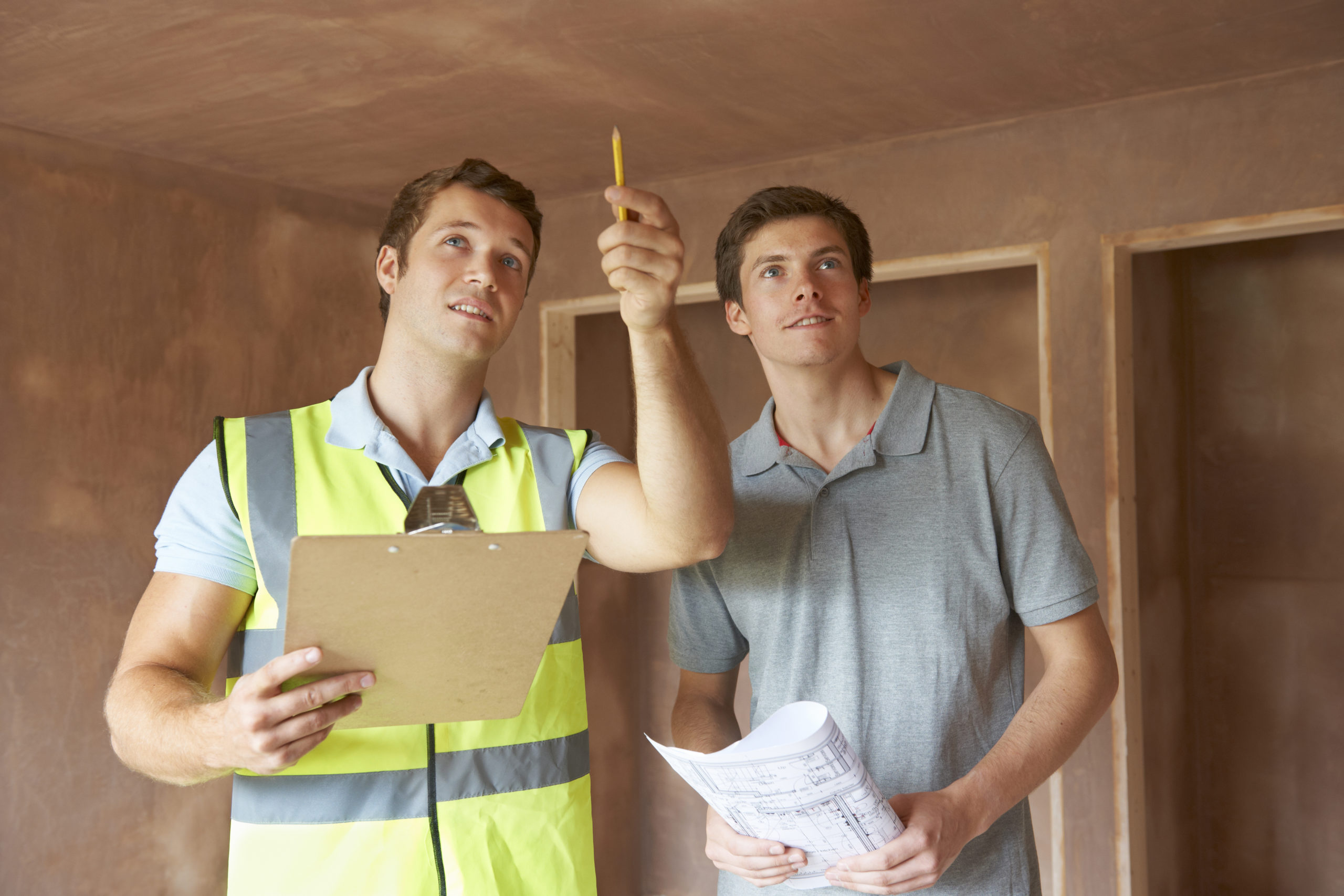 2 men are inspecting home interior for AC installation